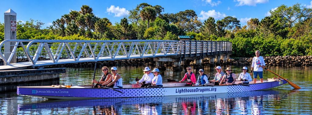 Lighthouse Dragons team members in their dragon boat on the water